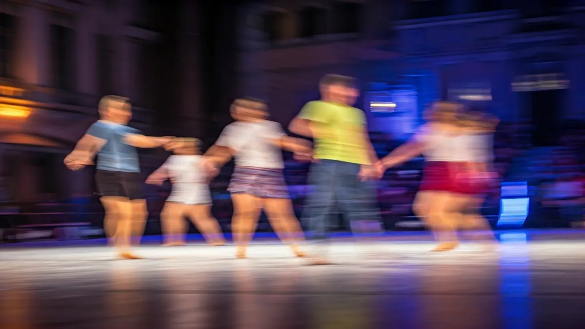 Irudi generikoa dantza moderno lehiaketa baten eszenatokiarena, argi koloretsuekin eta dantzarien mugimendu lausoekin.