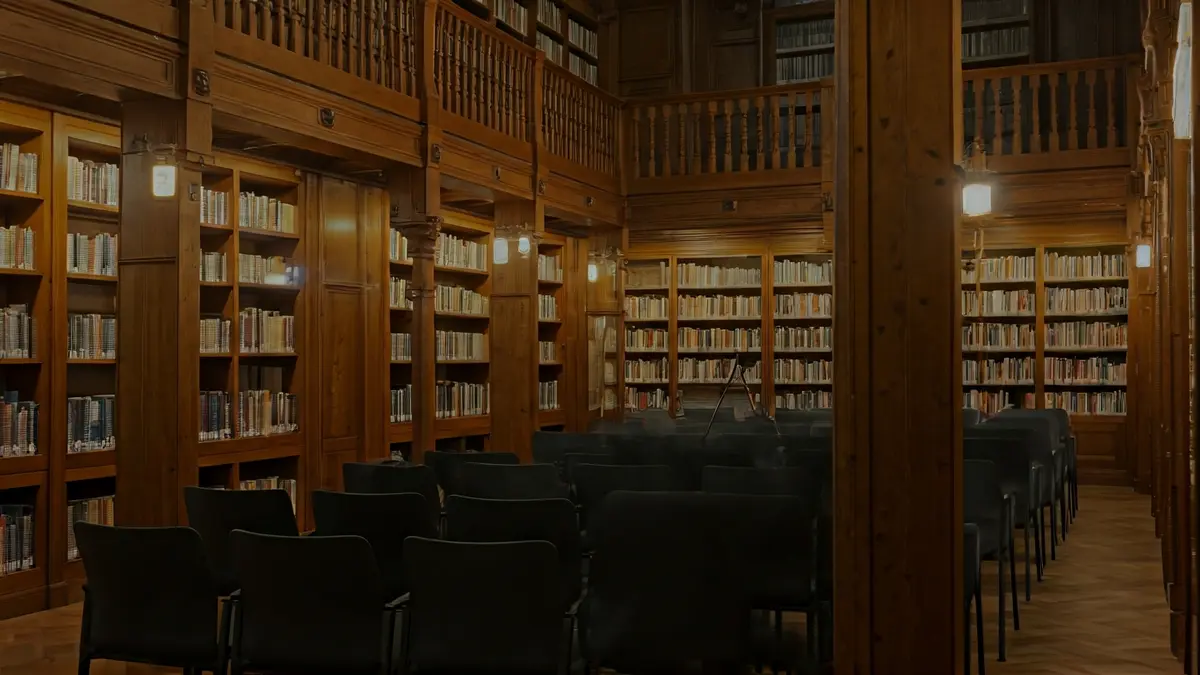 Irudi generikoa liburutegi baten barrualdekoa, egurrezko apalategiekin eta mikrofono batekin.