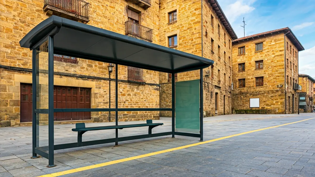 Generic image of a bus stop, with traditional Basque architecture in the background.