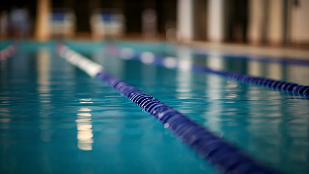 Irudi generikoa igerileku bateko kale baten, ur gardenarekin eta argien isla lausoekin.