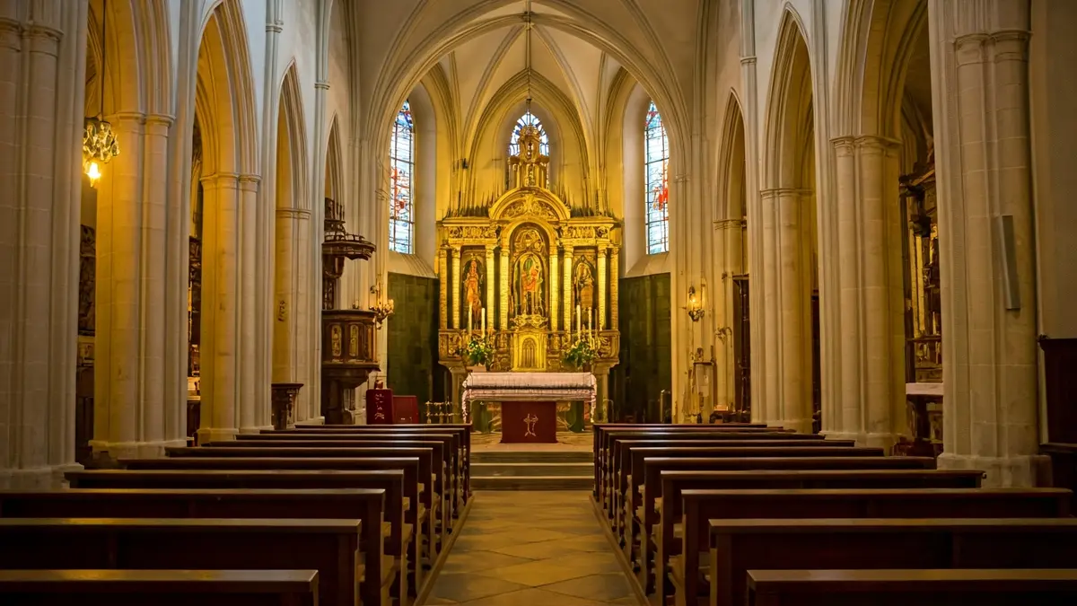 Imagen genérica del interior de una iglesia, con un altar iluminado y detalles religiosos.