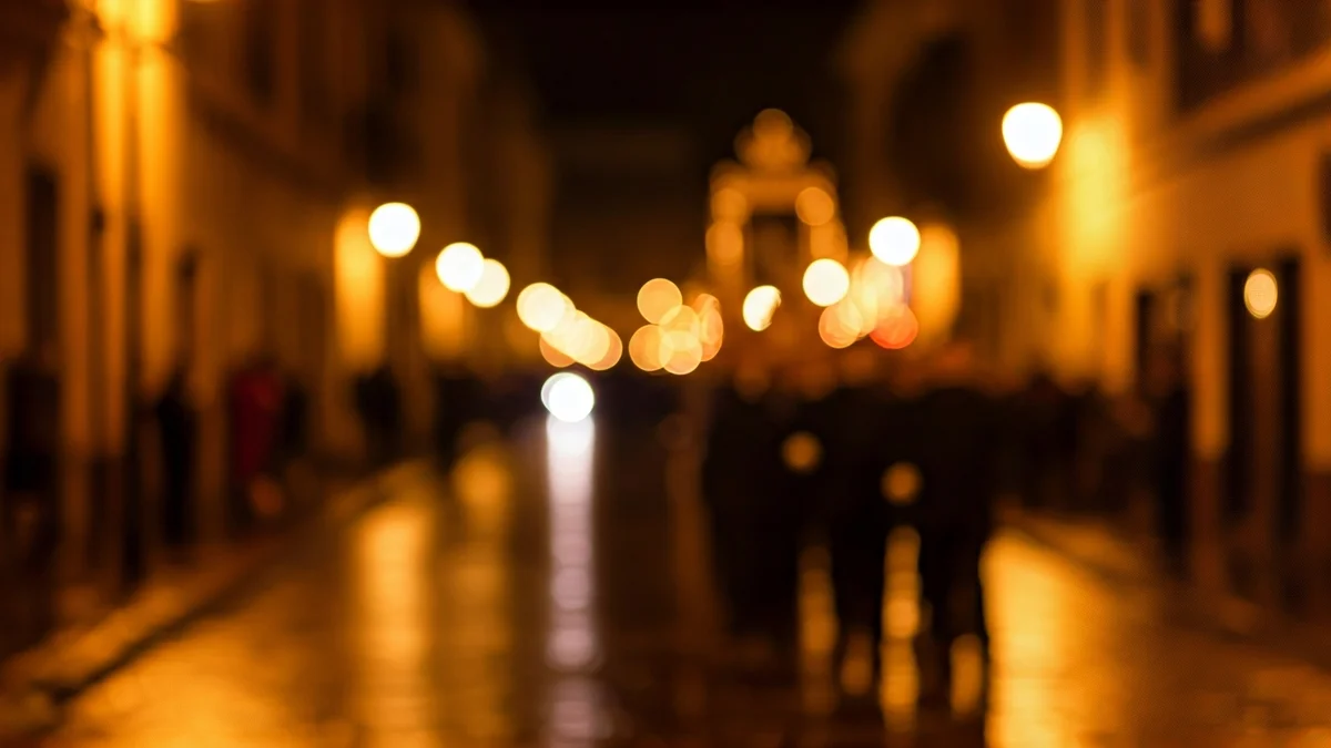 Bilboko Aste Santuko prozesio baten irudi atmosferikoa, euriak bustitako kaleetan zehar, argi lausoekin.