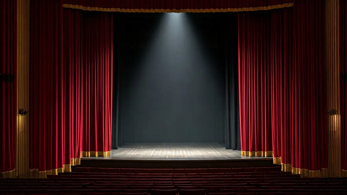 Imagen genérica de un escenario de teatro vacío, con cortinas rojas y un único foco.