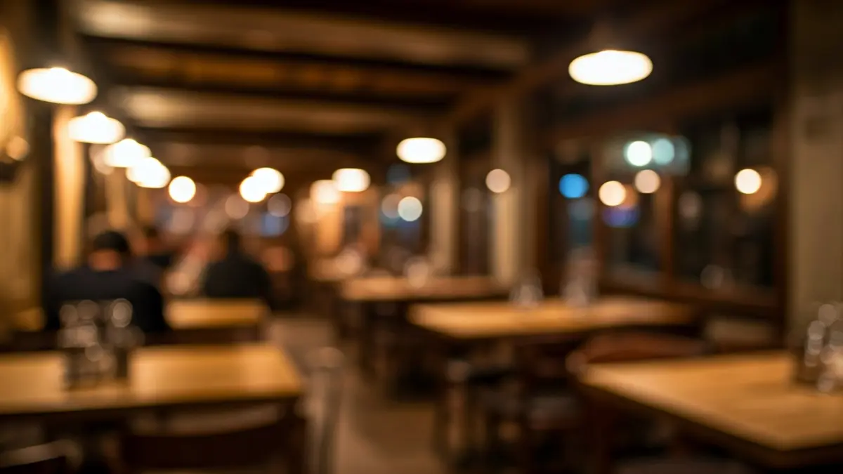 Irudi generikoa jatetxe baten barrualde atseginekoa, argi epelarekin eta egurrezko mahaiekin.