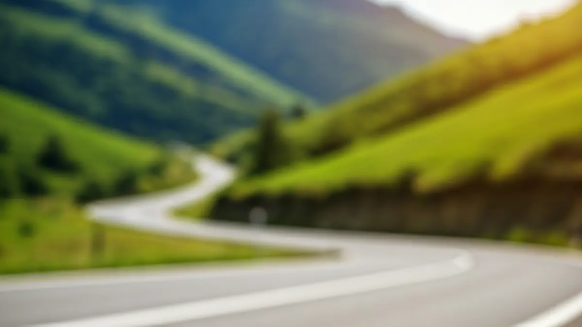 Generic image of a close-up of a bicycle wheel on a road winding through the green hills of the Basque landscape.