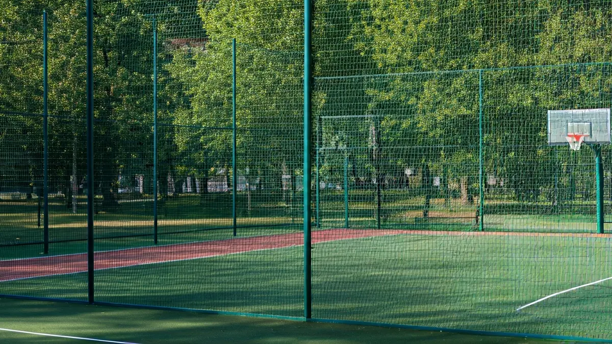 Imagen genérica de una cancha multideporte con césped artificial y canastas de baloncesto.