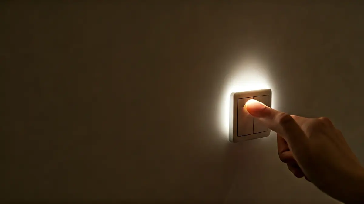 Imagen genérica de una mano apagando un interruptor de luz, representando el ahorro de energía.