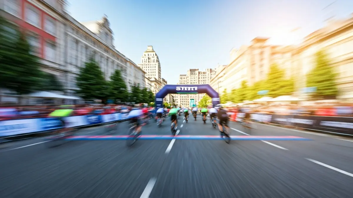 Generic image of a cycling race starting line, with crowds and urban architecture in the background.