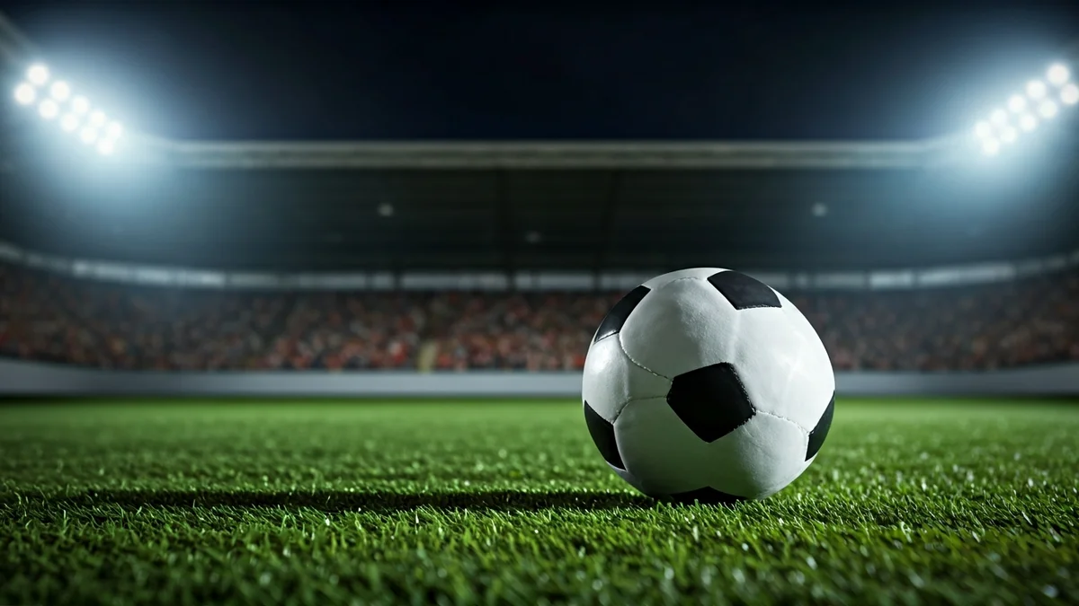 Imatge genèrica d'una pilota de futbol en un camp amb gespa artificial sota els focus d'un estadi