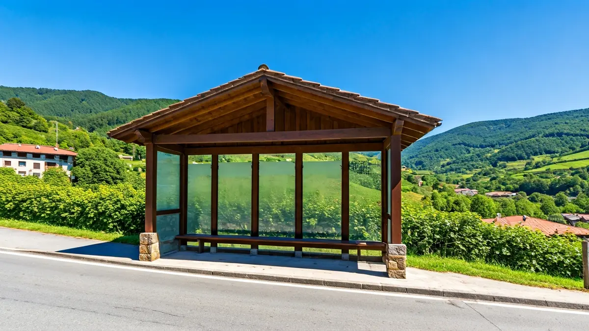 Irudi generikoa landa-herri bateko autobus geltoki huts bati buruz, atzealdean muino berdeak dituela.