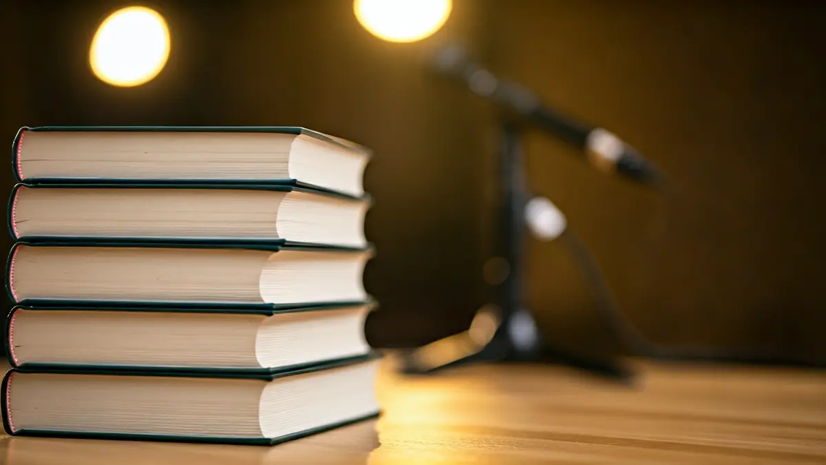 Generic image of a stack of books and a microphone, suggesting a calm reading atmosphere.