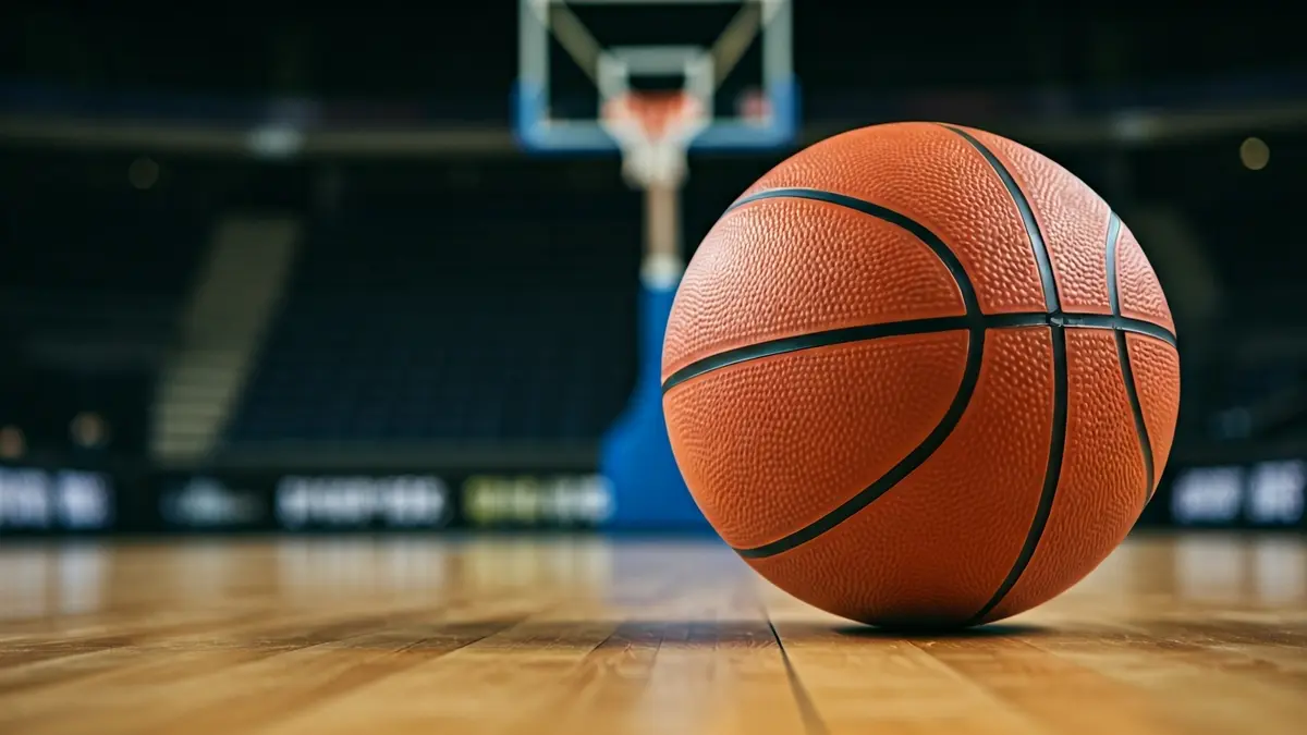 Generic image of a basketball on a court, with a blurred hoop in the background.