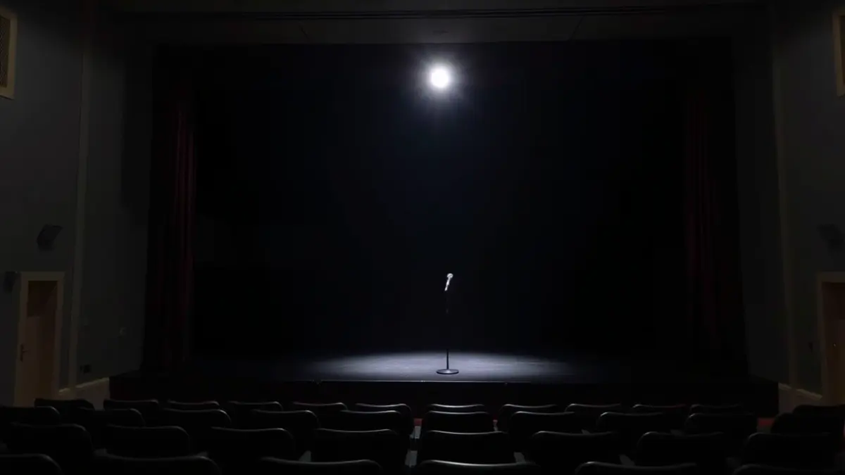 Antzoki ilun baten irudi generikoa, mikrofono bat agertokian foku baten azpian.