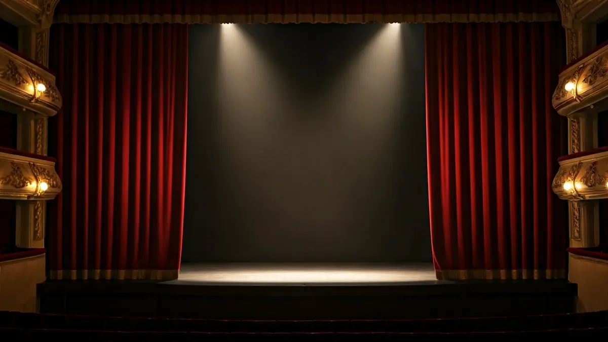 Imagen genérica de un teatro vacío con un foco de luz y una cortina roja.