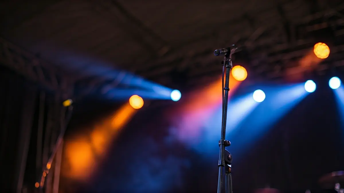 Generic image of a rock concert stage, with blurred lights and a microphone stand.