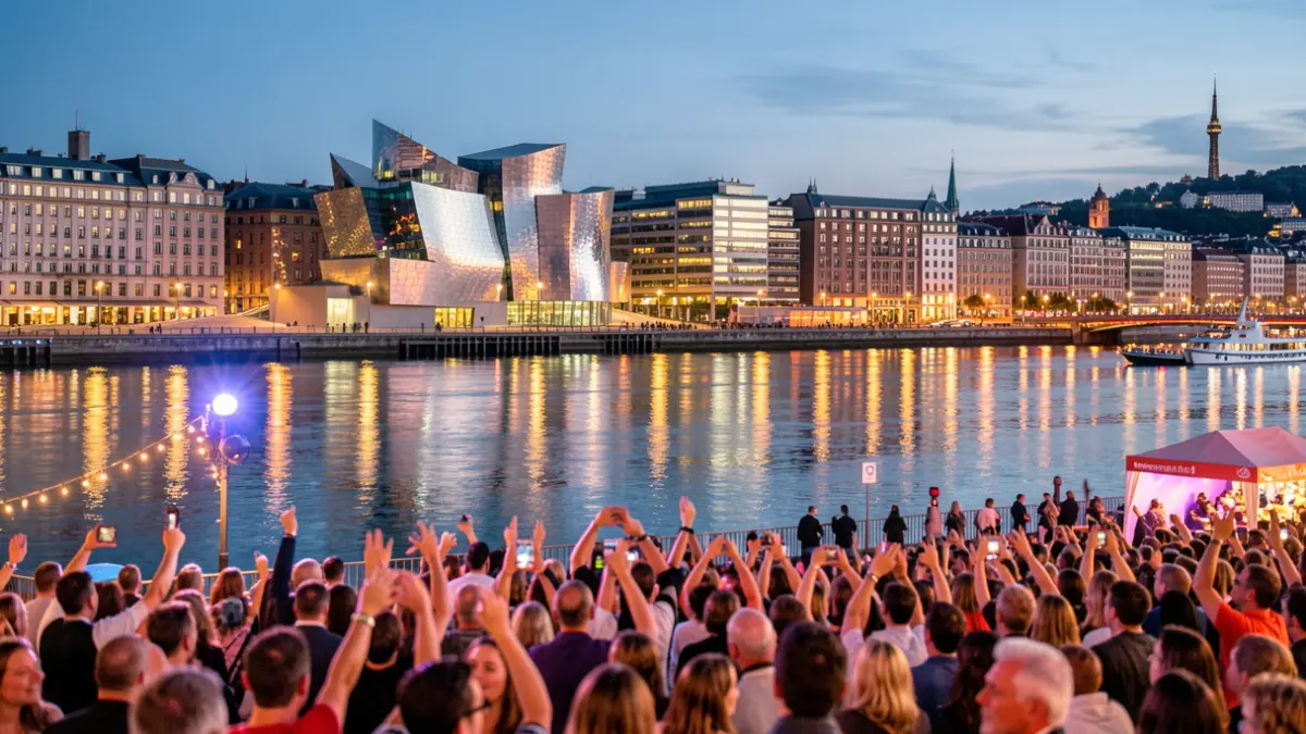 Imagen de la ciudad de Bilbao al atardecer, con el Museo Guggenheim iluminado y el reflejo del río Nervión.