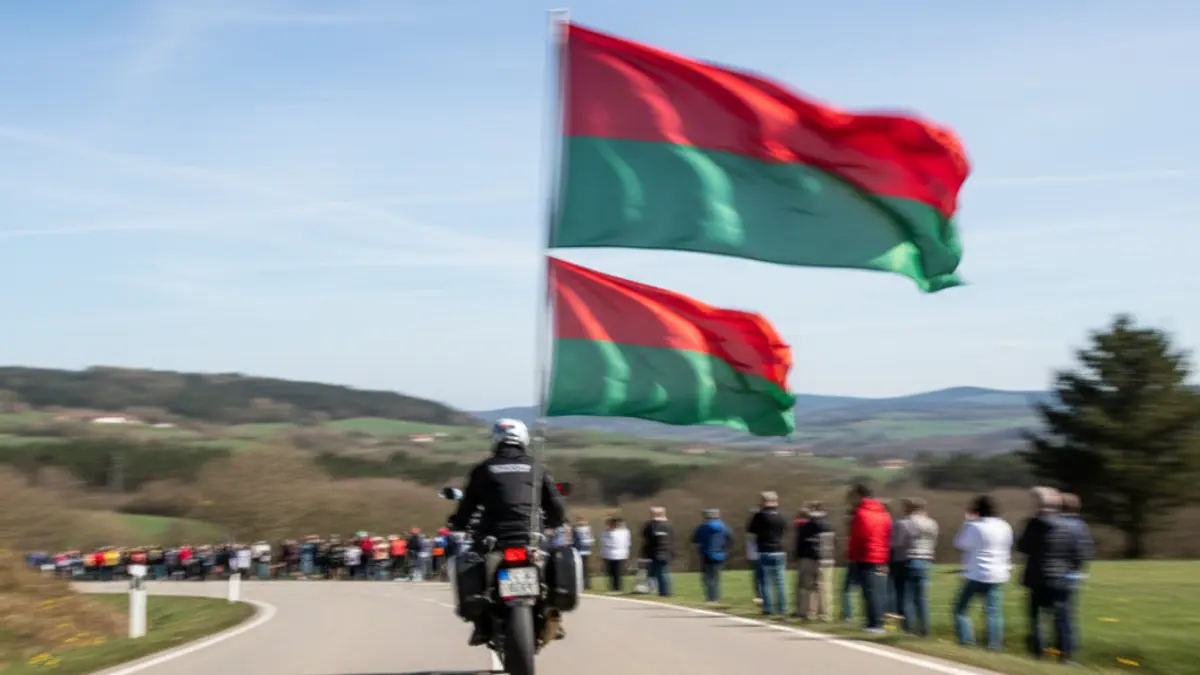 Generic image of blurred green and red flags on a road, indicating the passage of a cycling race.