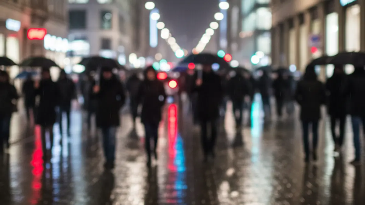 Imagen genérica de una calle de noche, con luces difusas y reflejos en el pavimento mojado.