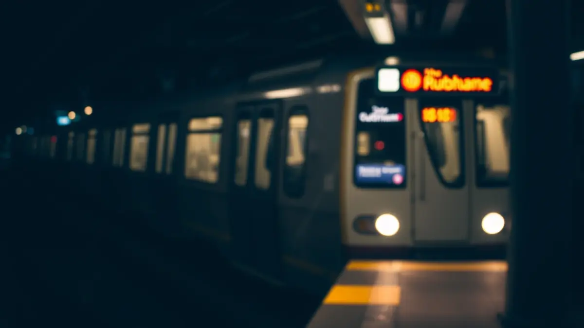 Metro geltoki batean iristen den tren baten irudi generikoa, gaueko argiekin.