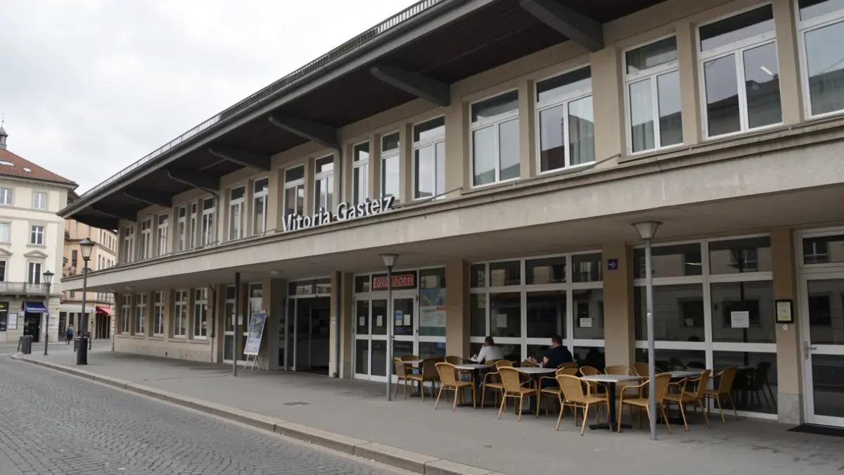 Exterior photograph of a bus station cafe with tables and chairs.
