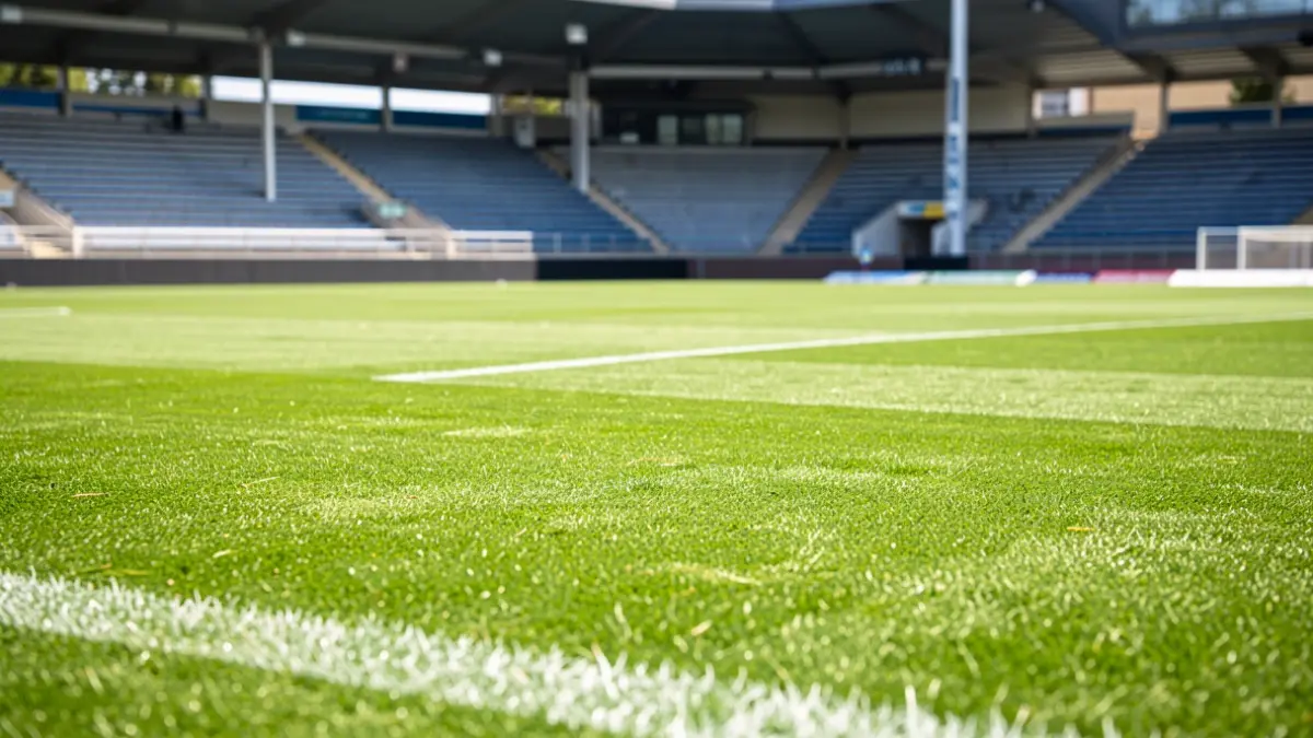 Futbol zelai bat Euskal Herrian, harmailak hutsik eta eguzki argia.