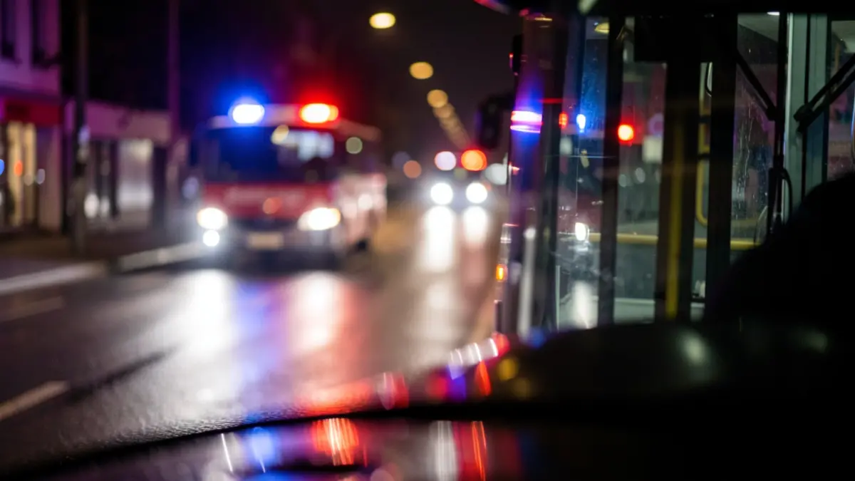 Generic image: wet road and emergency lights at night.
