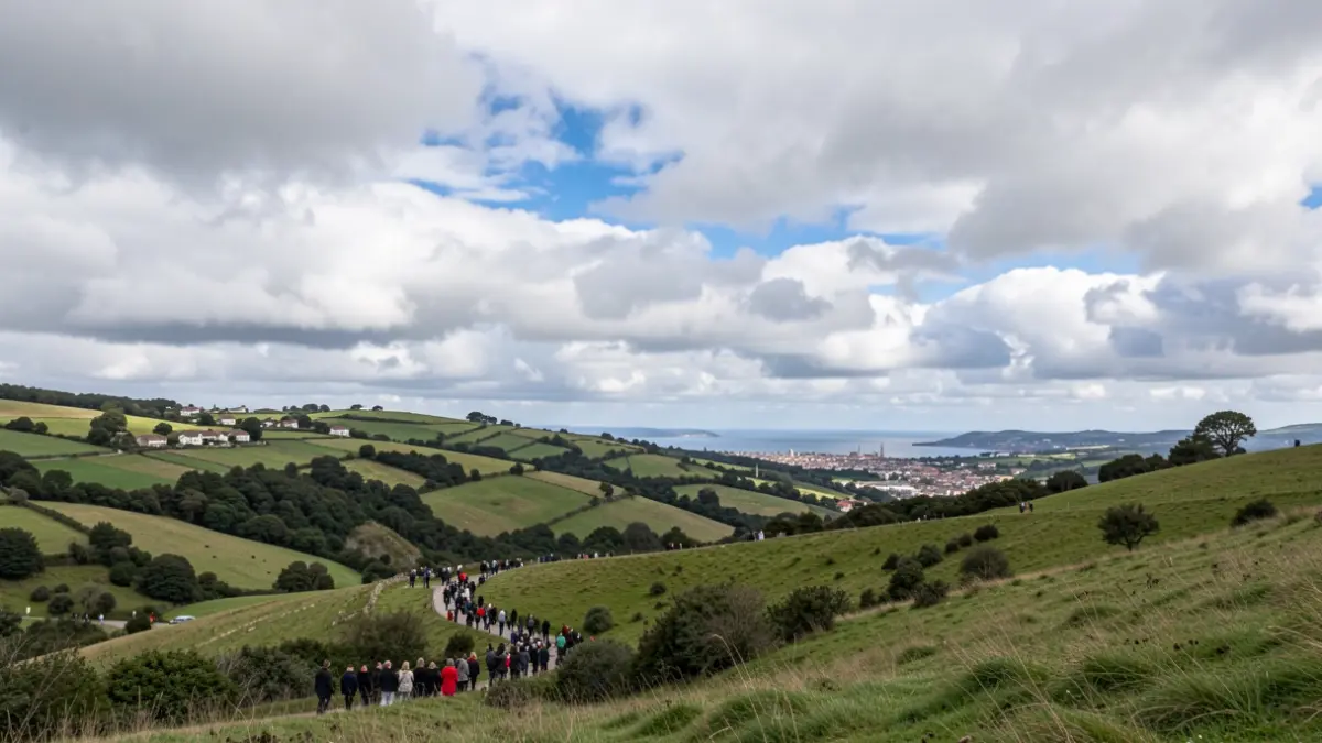 Cloudy sky with clearings over green Basque hills.