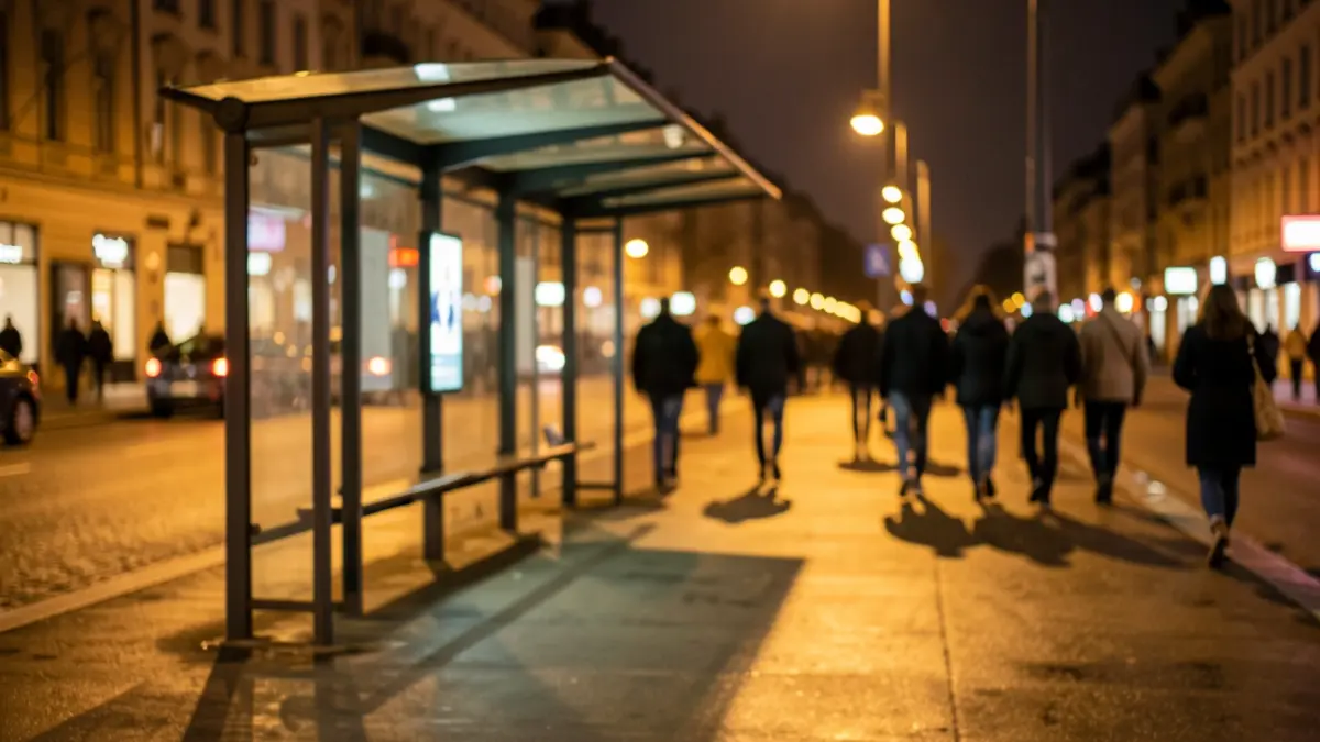 Imagen genérica de una marquesina de autobús nocturna, con luces artificiales y pavimento mojado.
