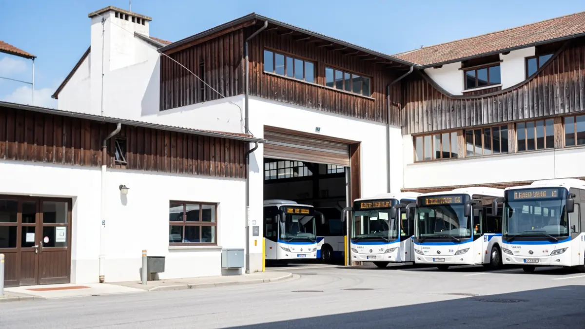 Exterior view of a Dbus bus depot in San Sebastian, with buses parked inside.